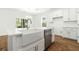 Bright kitchen features white cabinets, stainless steel appliances, farmhouse sink and wood flooring at 1630 Balsam St, Charleston, SC 29407