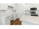 Elegant kitchen showcases white cabinetry, stainless steel appliances, stone countertops, and wood flooring at 1630 Balsam St, Charleston, SC 29407