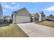 View of gray home featuring an attached garage, driveway, and well-maintained landscaping at 1941 Zonny Moss Dr, Johns Island, SC 29455