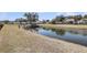 View of the pond behind the home, a well-maintained lawn and some shrubbery along the water at 1941 Zonny Moss Dr, Johns Island, SC 29455