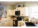 The kitchen area features a sink, window, black appliances and white cabinets at 203 Candleberry Cir, Goose Creek, SC 29445