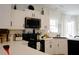 Charming kitchen features white cabinets, black appliances, and modern fixtures at 203 Candleberry Cir, Goose Creek, SC 29445