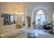 Bright living room with a tall ceiling, comfortable seating, and large arched windows with floral curtains at 203 Candleberry Cir, Goose Creek, SC 29445