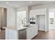 Modern kitchen boasts a white cabinets, stainless steel appliances, and large center island with sink at 217 Denham St, Summerville, SC 29486