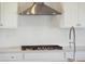 Close up of a kitchen featuring white cabinets, stone countertops, stainless steel gas range, and subway tile backsplash at 217 Denham St, Summerville, SC 29486