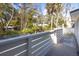 Bright balcony with white railing offering a scenic view of trees and houses in the neighborhood at 29 27Th Ave, Isle of Palms, SC 29451