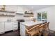 Spacious kitchen features stone counters, eat-in island, rattan stools, open shelving, and modern appliances at 29 27Th Ave, Isle of Palms, SC 29451