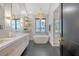 Modern bathroom featuring a double vanity, soaking tub, herringbone tile, and elegant lighting fixtures at 299 Bampfield Dr, Mount Pleasant, SC 29464
