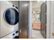 Bright, tidy laundry room with stacked washer and dryer, leading into a beautifully decorated bathroom at 299 Bampfield Dr, Mount Pleasant, SC 29464