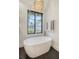 Bright bathroom with a freestanding tub, modern light fixture, and view of the outdoors at 299 Bampfield Dr, Mount Pleasant, SC 29464