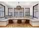 Bright dining room features built-in seating, large windows and modern chandelier over a wood table at 299 Bampfield Dr, Mount Pleasant, SC 29464