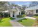 Charming exterior of white home featuring manicured lawn, guest house, and inviting walkway at 299 Bampfield Dr, Mount Pleasant, SC 29464