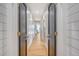 Hallway with hardwood floors, white shiplap walls, and dark-colored doors with brass hardware at 299 Bampfield Dr, Mount Pleasant, SC 29464