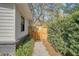Charming side yard features a wooden gate, lush greenery, and leads to a tranquil outdoor space at 299 Bampfield Dr, Mount Pleasant, SC 29464