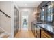 Stylish wet bar with sleek black cabinetry, gold hardware, and open doorway leading to a modern kitchen at 299 Bampfield Dr, Mount Pleasant, SC 29464