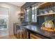 Modern wet bar features dark cabinetry, granite countertops, gold accents, and a view into the kitchen at 299 Bampfield Dr, Mount Pleasant, SC 29464