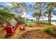 Tranquil backyard featuring Adirondack chairs, a fire pit, lush landscaping, and waterfront views at 3034 Maritime Forest Dr, Johns Island, SC 29455