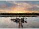 Picturesque waterfront dock at sunset featuring benches, a kayak, and a small boat for enjoying peaceful water activities at 3034 Maritime Forest Dr, Johns Island, SC 29455