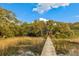Private home featuring a long wooden dock leading to a screened in porch with serene water views at 3034 Maritime Forest Dr, Johns Island, SC 29455