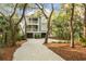 Charming two-story home with a double garage, and a gravel driveway lined with trees at 3034 Maritime Forest Dr, Johns Island, SC 29455