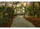 Charming multi-story home with double garage nestled among mature trees and manicured landscaping with a gravel driveway at 3034 Maritime Forest Dr, Johns Island, SC 29455