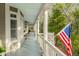 Covered porch featuring columns and waterfront views, complete with an American flag at 3034 Maritime Forest Dr, Johns Island, SC 29455