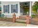 Inviting front porch with brick steps, lantern detail, black iron fence and ceiling fans at 312 White Gables Dr, Summerville, SC 29483