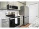 Updated kitchen showcasing stainless steel appliances, sleek grey cabinets, and modern countertops at 319 Bluebell Ave, Summerville, SC 29483