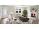 Bright living room featuring a cozy fireplace, large window, hardwood flooring, and neutral-toned furniture at 319 Bluebell Ave, Summerville, SC 29483