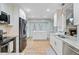Bright kitchen showcases stainless appliances, white cabinets, granite countertops, and an island with french doors at 32 Monte Sano Dr, Hanahan, SC 29410