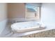 Luxurious bathroom featuring a soaking tub with jets and a lovely window view at 3274 Heathland Way, Mount Pleasant, SC 29466