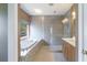 Elegant bathroom featuring a soaking tub, walk-in shower, and a wooden vanity at 3274 Heathland Way, Mount Pleasant, SC 29466