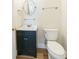 Charming half bathroom with a black vanity, round mirror, and wood-look floor at 3274 Heathland Way, Mount Pleasant, SC 29466
