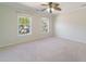 A spacious bedroom with two windows, a ceiling fan, and neutral-colored carpet provides a bright and airy space at 3274 Heathland Way, Mount Pleasant, SC 29466
