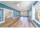 Inviting living room featuring hardwood floors, custom shelving, lots of windows, and double French doors to hallway at 3274 Heathland Way, Mount Pleasant, SC 29466
