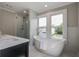 This spa-like bathroom features a soaking tub and glass enclosed shower with bright windows at 35 Cypress St, Charleston, SC 29403