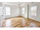 A bright, spacious bedroom with hardwood floors, white trim, a ceiling fan and two large windows at 3853 Delinger Dr, Mount Pleasant, SC 29466