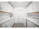 Bright, modern laundry room offers sleek white cabinets, counter space, and a patterned floor beneath at 436 Rowley Ln, Summerville, SC 29486