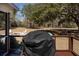 View of lush backyard with barbeque grill, mature trees, and firepit at 6118 Hazelhurst Ln, Ravenel, SC 29470