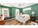 Bedroom featuring a white bed frame, hardwood floors, and multiple windows at 6118 Hazelhurst Ln, Ravenel, SC 29470