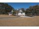 Side view of white farmhouse featuring a carport and gravel driveway on a sprawling lawn at 6118 Hazelhurst Ln, Ravenel, SC 29470