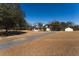 Charming white farmhouse with a detached garage, carport and gravel driveway at 6118 Hazelhurst Ln, Ravenel, SC 29470