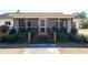 Exterior view of screened porch, wood stairs and manicured landscaping at 6118 Hazelhurst Ln, Ravenel, SC 29470