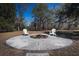 Outdoor fire pit with chairs, perfect for entertaining on a circular paver patio beneath mature trees at 6118 Hazelhurst Ln, Ravenel, SC 29470