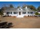 Charming home with a welcoming front porch, mature landscaping, and a manicured lawn at 6118 Hazelhurst Ln, Ravenel, SC 29470