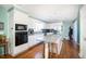 Spacious kitchen featuring white cabinetry, stainless steel appliances, and a central island with bar seating at 6118 Hazelhurst Ln, Ravenel, SC 29470