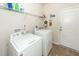Functional laundry room with washer, dryer, shelving, and access door at 613 Zinnia Dr, Goose Creek, SC 29445
