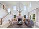 Sun-filled living room with a soaring ceiling, fireplace, and elegant chandelier at 5215 Cottage Lndg Dr, Summerville, SC 29485