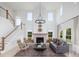 Sun-filled living room with a soaring ceiling, fireplace, and elegant chandelier at 5215 Cottage Lndg Dr, Summerville, SC 29485