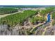 An aerial view showing a stream running through an expansive, heavily wooded, lot with patches of open fields at 732 Lindhaven Dr, Pineville, SC 29468